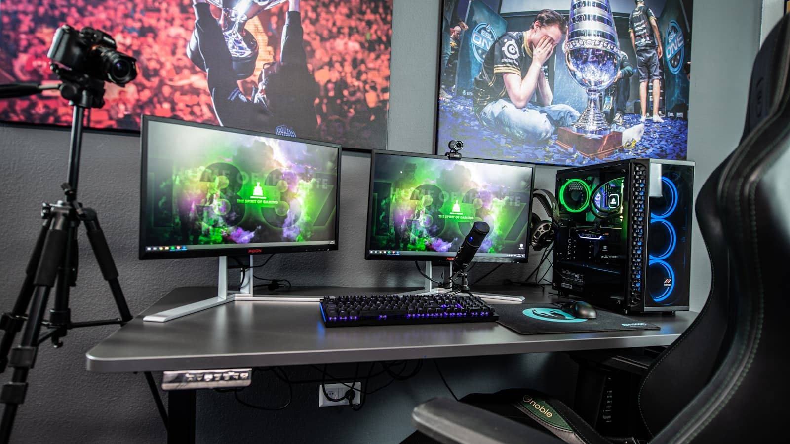 Creator's desk setup with multiple monitors, a camera on a tripod and studio lighting