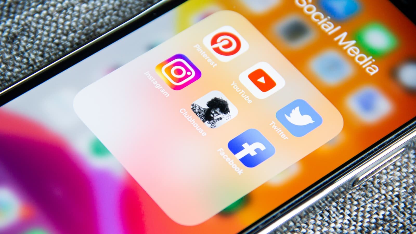 Close-up of a smartphone home screen showing a folder of social media applications