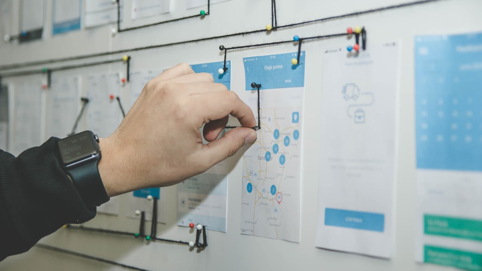 Person drawing a flowchart of connected decision boxes on a whiteboard